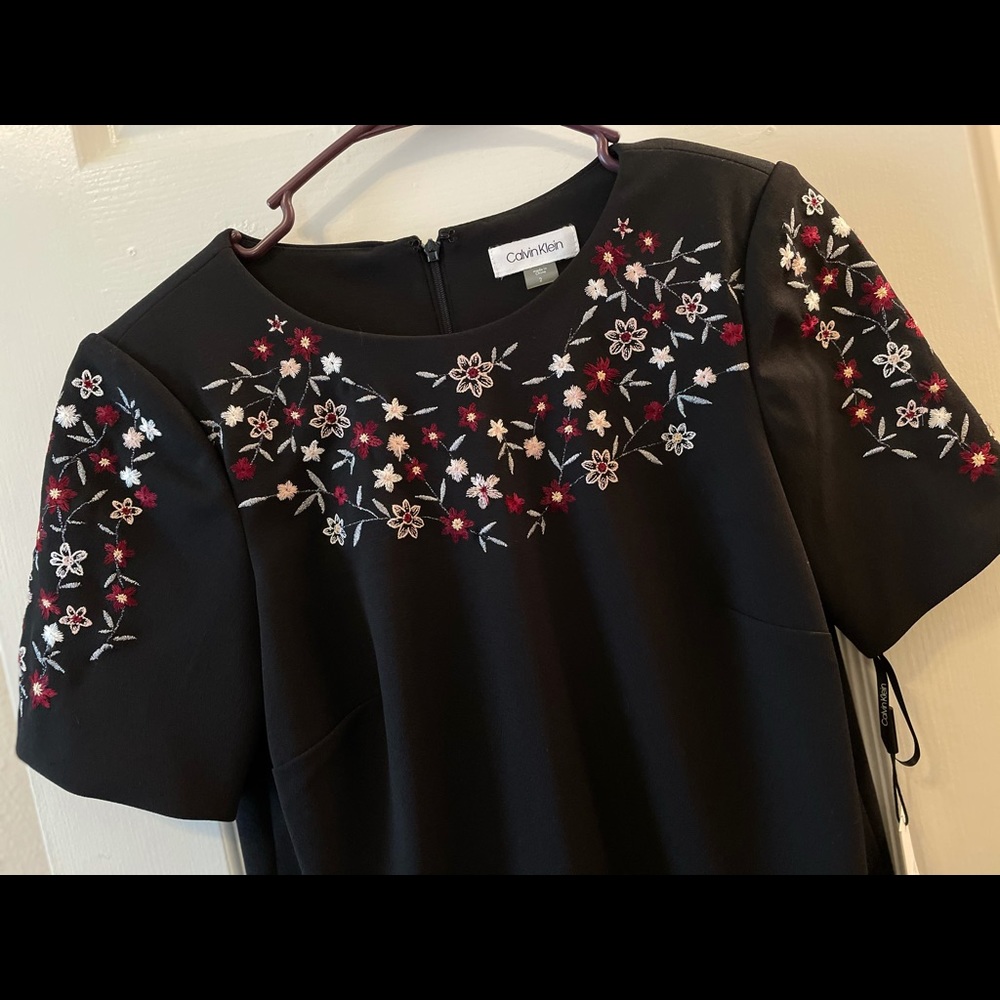 Black mini dress with embroidery .